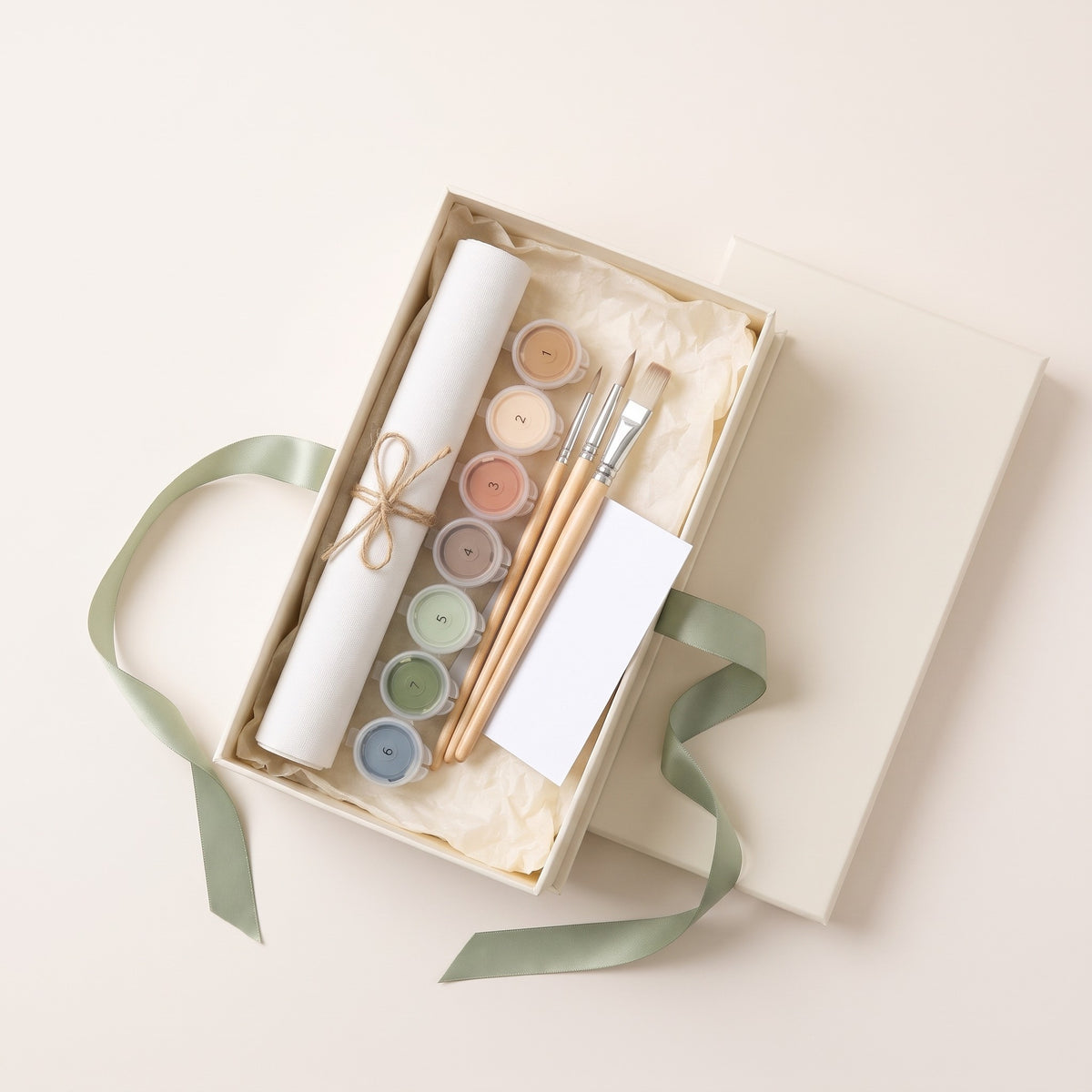 Open gift box with rolled canvas, numbered paints, brushes and a blank card